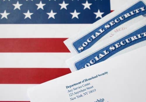 2 social security cards laying on american flag