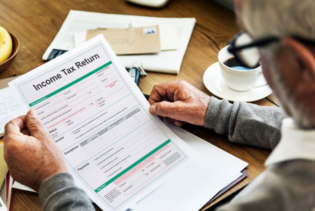 Are Annuities Taxable page picture of older gentleman look at income tax forms