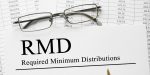 59 1/2 r and rmd withdrawal rules - rmd in bold letters on paper with spreadsheet in background.