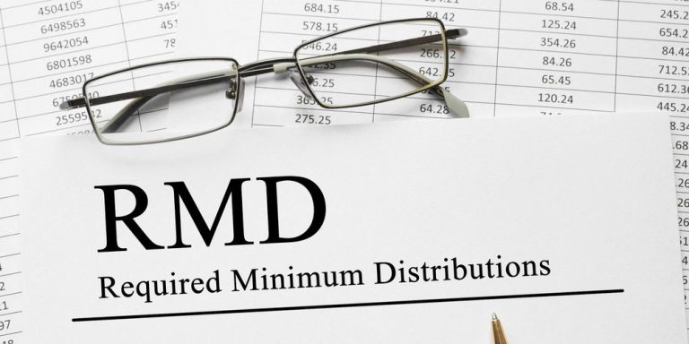 59 1/2 R and RMD withdrawal rules - RMD in bold letters on paper with spreadsheet in background.