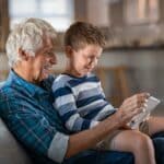 Athene annuity review grandfather and grandchild using digital tablet together